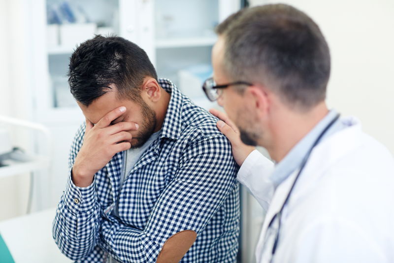 Médico dando consuelo a un padre desanimado 