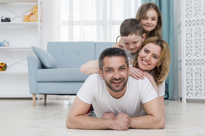 Una familia sonriendo en su propio hogar
