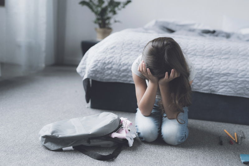 Una niña tumbada en el suelo de su habitación