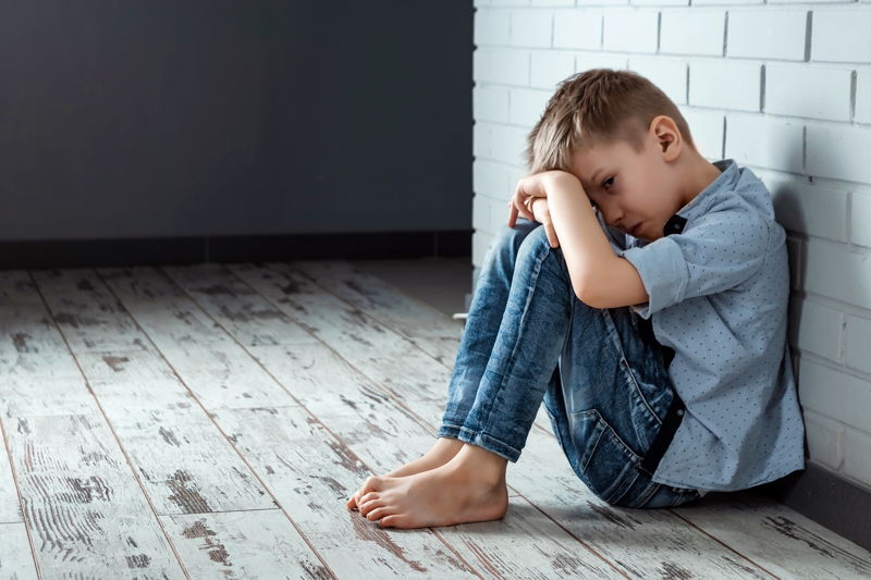 Niño triste en un rincón