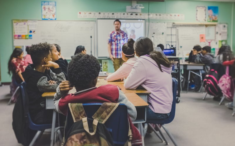 Profesor dando clase a estudiantes adolescentes