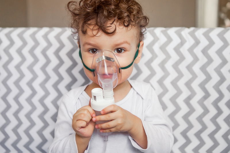 Niño con mascarilla para facilitar la respiración