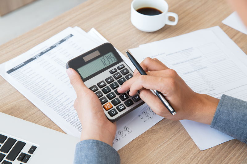 Hombre haciendo cálculos con una calculadora