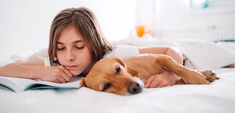 Niño triste con su perro que le hace compañía