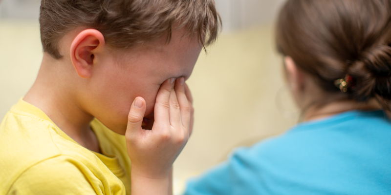 Niño tapándose la cara porque está experimentado una multitud de emociones