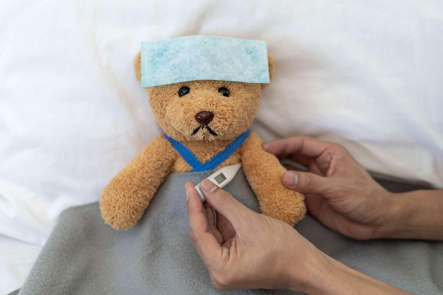 osito-peluche-simbolizando-niño-enfermo-cama-hospital-termometro