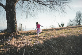 Girl in the woods near a tree with a swing