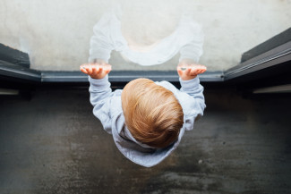 Child looking through a window