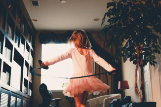 Gillr in a pink dress playing with a rope