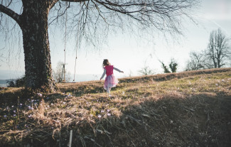 Girl in the woods near a tree with a swing