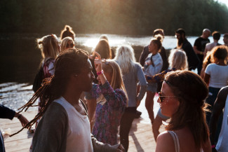 Group of people standing on dock beside body of water