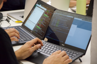 Two participants working shoulder to shoulder in the Rarehacks event