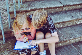 Two kids filling up a form