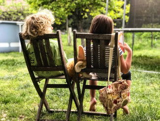 Siblings sitting on a backyard