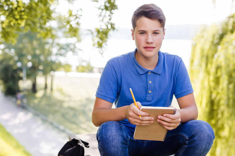 Adolescente a la salida del colegio con su cuaderno y lápiz
