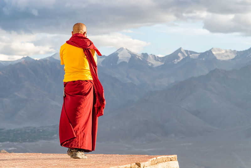 Monje tibetano mirando una montaña